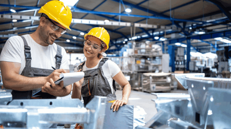 Deux ouvriers en équipement de sécurité échangeant sur un site industriel pour la prévention des risques professionnels.