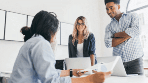 Trois collaborateurs en réunion stratégique analysant la RGDU et le paramètre SMIC pour optimiser les cotisations patronales.