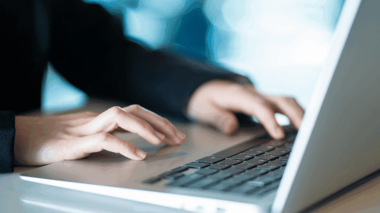 Professionnelle RH analysant des données sur son ordinateur pour assurer la sécurisation paie de l'entreprise.